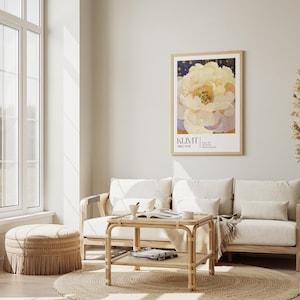 May include: A framed wall art print featuring a large, pale yellow and white peony flower against a dark blue starry background, with the text KLIMT 1862-1918 printed in black at the bottom, displayed in a light wood frame on a neutral wall.
