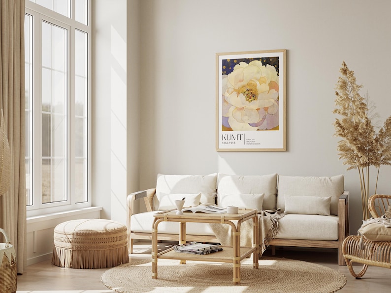 May include: A framed wall art print featuring a large, pale yellow and white peony flower against a dark blue starry background, with the text KLIMT 1862-1918 printed in black at the bottom, displayed in a light wood frame on a neutral wall.