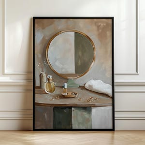 May include: A framed wall art print depicting a vanity table with a round gold-rimmed mirror, two glass perfume bottles, a small wooden tray, and several gold rings scattered across the surface, all rendered in a soft, painterly style.