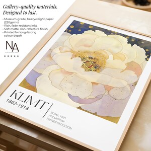 May include: A framed art print featuring a large, stylized cream-colored flower with gold-dotted centers against a dark blue background. The print includes the text KLIMT 1862-1918, ROMA, 1891, VER SACRUM, and WIENER SECESSION in black lettering.