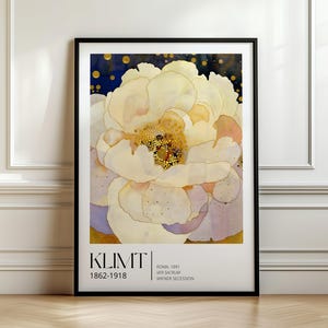 May include: A framed art print featuring a large, pale yellow and white flower with soft, layered petals against a dark blue background with gold dots. The text KLIMT 1862-1918, ROMA, 1891, VER SACRUM, and WIENER SECESSION is printed in black at the bottom.
