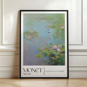 Puede incluir: Una lámina de arte enmarcada con una pintura de nenúfares de Claude Monet en tonos suaves de azul, verde y rosa. El borde blanco inferior muestra el texto MONET, los años 1840-1926 y la cita Every day I discover more and more beautiful things.