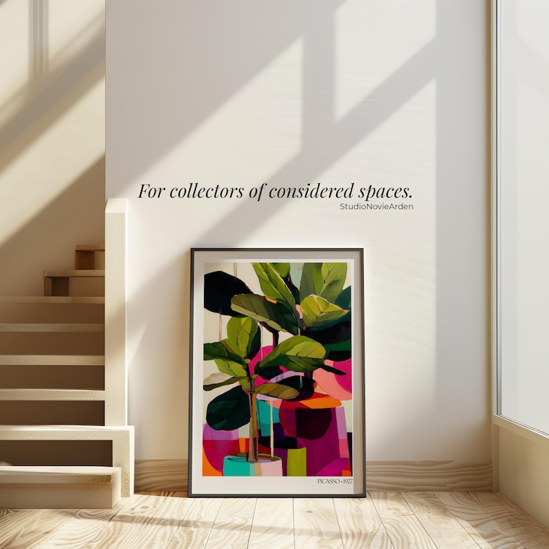 May include: A framed art print featuring a stylized fiddle leaf fig plant with large green leaves, set against a vibrant, abstract background of pink, orange, and teal geometric shapes. The text "PICASSO 1927" is printed at the bottom of the print.
