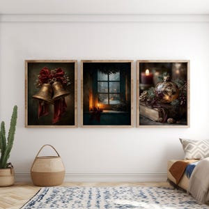 Può includere: Un set di tre stampe artistiche da parete incorniciate. La stampa a sinistra mostra due campane dorate con un fiocco rosso. Quella centrale raffigura una finestra con vista su una scena innevata e una candela. Quella a destra mostra un ornamento.