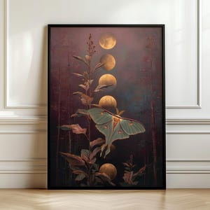 May include: A framed vertical wall art print featuring a pale green luna moth resting on a tall plant stem. Above the moth, a series of golden moon phases descends through a dark, moody forest background with deep purple and brown tones.