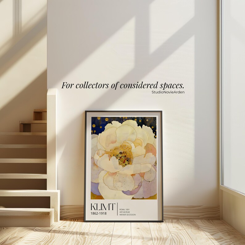 May include: A rectangular framed art print featuring a large, pale yellow and white flower with a dark blue background. The text KLIMT 1862-1918, ROMA 1891, VER SACRUM, and WIENER SECESSION is printed at the bottom. The wall above displays For collectors of considered spaces. StudioNovieArden.