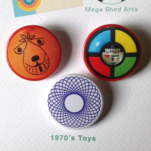 May include: A selection of retro-style badges and a print. The badges display a cartoon dog, a Simon game design, and a blue and white geometric pattern. The print reads "The Super 70s". The text "1970's Toys" is also visible.