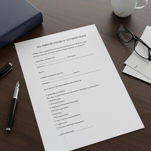 May include: A printed all-purpose power of attorney form on a wooden desk. The form is white with black text and includes sections for principal information, agent, and grant of authority. A black pen, a cup of coffee, glasses, and a blue book are also on the desk.