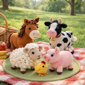 May include: A collection of handmade crochet farm animals, including a brown horse, a black and white cow, a white sheep, a pink pig, and a yellow chick. They are arranged on a green mat over a red and white checkered blanket.
