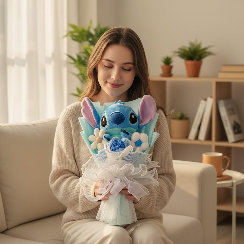 Peut inclure: Un bouquet en peluche avec un personnage Stitch bleu aux grandes oreilles, entour&eacute; de fleurs d&eacute;coratives blanches et bleues. Le bouquet est envelopp&eacute; de papier bleu clair et de dentelle blanche, nou&eacute; avec un ruban blanc.