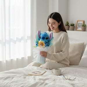 May include: A bouquet featuring a blue plush Stitch character with large ears, a yellow sunflower, and blue and white accents. The bouquet is wrapped in light blue paper and white tulle.