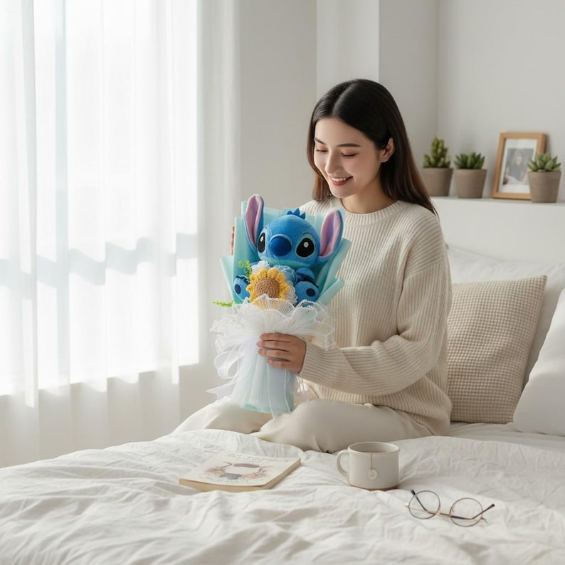 May include: A bouquet featuring a blue plush Stitch character with large ears, a yellow sunflower, and blue and white accents. The bouquet is wrapped in light blue paper and white tulle.