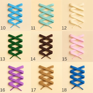 May include: A collection of colorful shoelaces arranged in a crisscross pattern. The laces are in various colors, including blue, teal, cream, green, brown, pink, purple, tan, and dark blue. Each pair is numbered from 10 to 18.