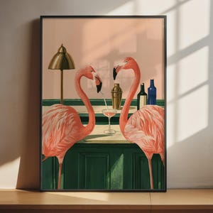 Peut inclure: Une impression d'art encadrée représentant deux flamants roses debout devant un comptoir de bar vert foncé. Entre eux se trouvent un verre à cocktail avec une paille, un shaker doré et deux bouteilles en verre. Une lampe de bureau dorée est posée.