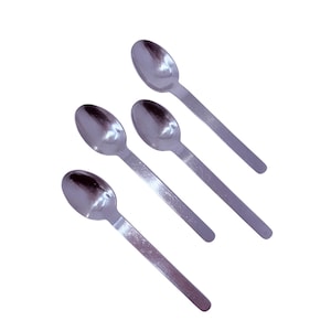 Puede incluir: Cuatro cucharas de acero inoxidable dispuestas en diagonal sobre un fondo blanco. Cada cuchara tiene un cuenco redondeado y un mango plano y rectangular. Las cucharas son reflectantes y brillantes.