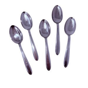 May include: Five polished silver spoons displayed against a white backdrop. Each spoon features a rounded bowl and a long, slender handle. The spoons are positioned at angles, forming a dynamic arrangement. Suitable for serving or eating.