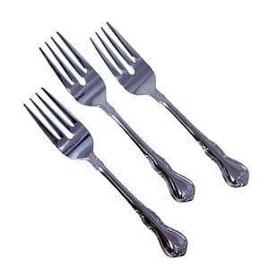 May include: Three shiny, silver forks with four tines each. The handles have a decorative, ornate design. The forks are arranged diagonally against a white background, showcasing their polished finish.