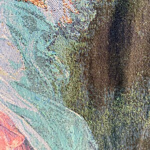 Pu&ograve; includere: Primo piano di un arazzo tessuto con un design dettagliato. L'arazzo presenta una miscela di colori, tra cui verde acqua, verde, marrone e sfumature di rosa. La trama &egrave; visibile, mostrando l'intricato motivo di tessitura.