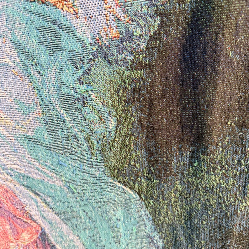 Pu&ograve; includere: Primo piano di un arazzo tessuto con un design dettagliato. L'arazzo presenta una miscela di colori, tra cui verde acqua, verde, marrone e sfumature di rosa. La trama &egrave; visibile, mostrando l'intricato motivo di tessitura.