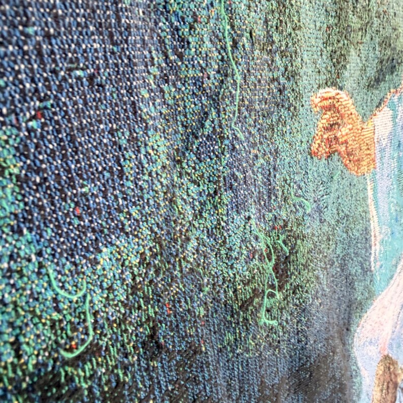 Pu&ograve; includere: Primo piano di un arazzo tessuto con una superficie strutturata. L'arazzo presenta una miscela di fili blu, verdi e neri, creando un motivo denso e dettagliato. Sono visibili accenni di una figura con abiti beige e blu sul lato destro.