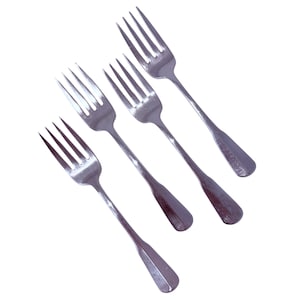 May include: Four silver forks with tines and long handles are arranged diagonally against a white background. The forks are made of a shiny metal, likely stainless steel, and are designed for dining.