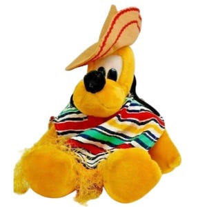 May include: A plush yellow dog wearing a sombrero and a striped shirt. The dog has black eyes and a black nose. The sombrero is tan with red stripes. The shirt has red, green, blue, and white stripes.