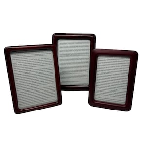 May include: Three wooden picture frames with dark red wood and glass fronts. Each frame contains a printed page of text.