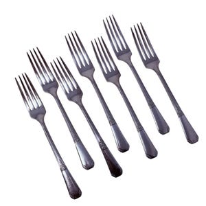 Può includere: Un assortimento di otto forchette d'argento, ciascuna con quattro rebbi e un manico decorativo. Le forchette sono disposte diagonalmente su uno sfondo bianco, mettendo in risalto il loro design elegante e la finitura lucida. Ideale per cene formali.
