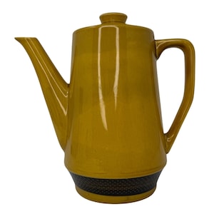 May include: A yellow ceramic coffee pot with a black and white geometric design around the base.