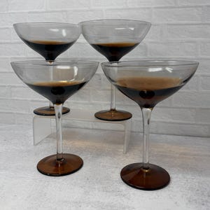 May include: A set of three ceramic mugs with a speckled, matte finish. The mugs are in shades of cream, light gray, and dark gray. Each mug has a simple, minimalist design and a rounded handle.