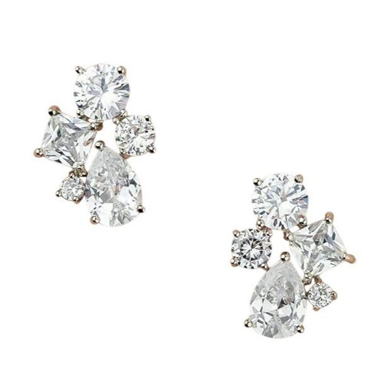 May include: A pair of sparkling stud earrings with a cluster design. Each earring features a mix of clear, round, square, and pear-shaped cubic zirconia stones set in a gold-tone metal. The earrings are displayed against a white background.