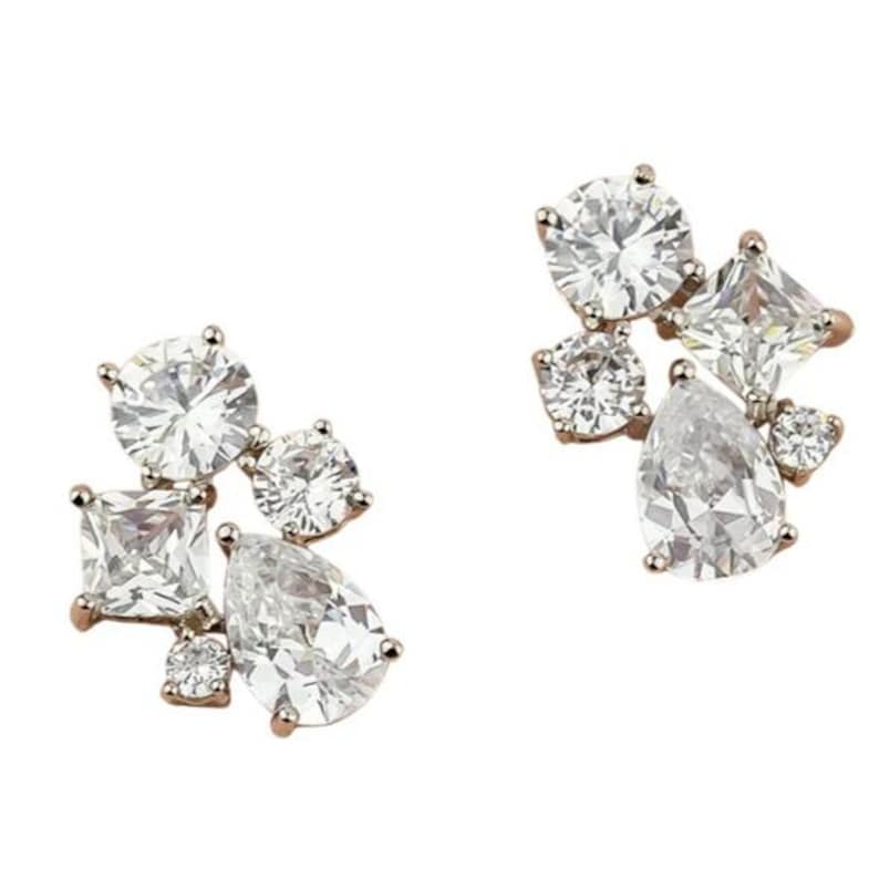 May include: A pair of rose gold stud earrings. Each earring features a cluster of clear, sparkling cubic zirconia stones in various shapes, including round, square, and pear-cut. The earrings are set against a white background.