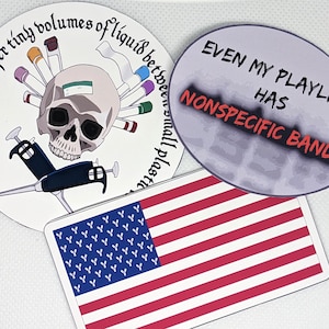 May include: A collection of stickers featuring science-themed designs. One sticker is round with a skull, test tubes, and the text "Born to transfer tiny volumes of liquid between small plastic." Another is oval with "EVEN MY PLAYLIST HAS NONSPECIFIC BANDS." An American flag sticker is also included.