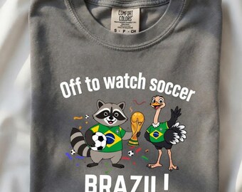 Comfort Colors  Off To Watch Soccer Shirt | Funny World Cup 2026 Gift |  Brazil National Team Art | Retro Raccoon & Ostrich Soccer T-Shirt