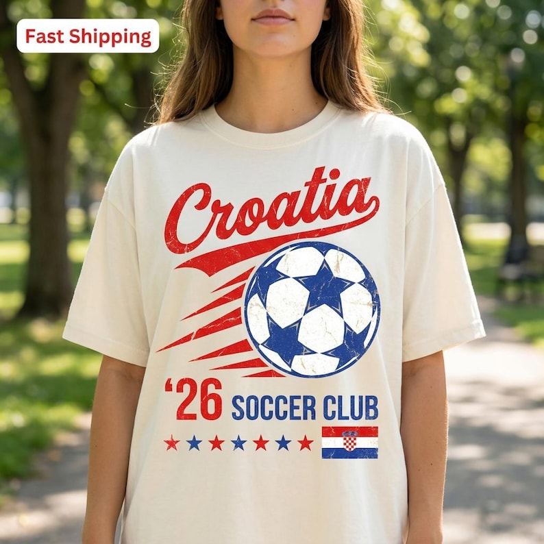 Op de afbeelding: Een cr&egrave;mekleurig t-shirt met een rode afbeelding met de tekst Croatia, een blauw-witte voetbal, de tekst '26 SOCCER CLUB, een rij van zeven rode en blauwe sterren en een kleine rechthoekige Kroatische vlag op de voorzijde.