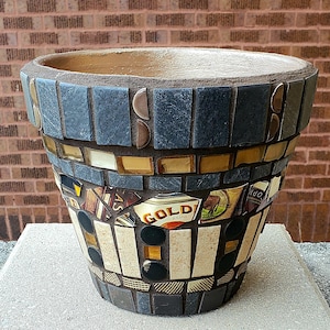 May include: A white ceramic mug with a black handle and the text "But First, Coffee" in a black, bold font. The mug is on a white surface.