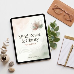 Peut inclure: Une tablette numérique affichant la couverture d'un cahier d'exercices intitulée Mind Reset & Clarity avec une illustration de fleur de lotus, des lavis aquarelle doux pêche et vert sauge, et des lignes ondulées. Le texte SalimaPrintableCo est en bas.