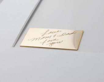 May include: A gold-colored metal plaque with the handwritten message "Love Mom + Dad Love you" engraved on it.