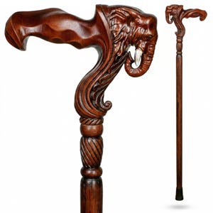 Puede incluir: Bastón de madera hecho a mano con una cabeza de elefante tallada en el mango. El bastón es de color marrón oscuro con detalles intrincados, incluyendo los colmillos del elefante y la veta de la madera texturizada. El bastón mide aproximadamente 91 cm de largo.