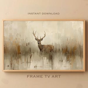 Puede incluir: Una impresión artística enmarcada que representa un ciervo en el agua, rodeado de juncos. La obra de arte utiliza una paleta de colores apagados de beige, marrón y gris. El texto "INSTANT DOWNLOAD" y "FRAME TV ART" son visibles.