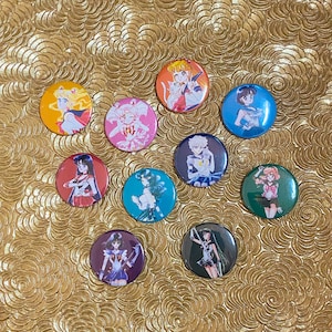 May include: Nine round pinback buttons featuring characters from the anime Sailor Moon. The buttons are colourful and feature different characters in various poses.