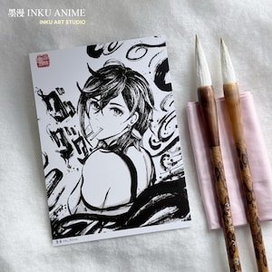Puede incluir: Una impresión artística de anime en blanco y negro que presenta un personaje con un cigarrillo, acompañada de dos pinceles de caligrafía y un paño rosa. La impresión incluye texto japonés y el nombre del estudio "INKU ANIME".