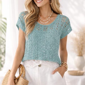 Puede incluir: Un top de ganchillo azul claro con cuello redondo y mangas cortas. El top se combina con pantalones cortos blancos y un bolso de mano de paja. El conjunto se complementa con joyas doradas, creando un look veraniego informal.