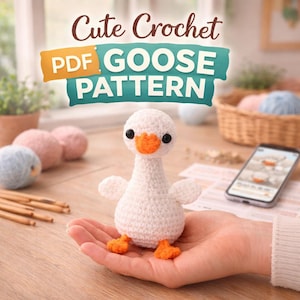 May include: A handmade white crochet goose with orange beak and feet. The goose is held in a hand, with the text "Cute Crochet PDF Goose Pattern" above. Crochet supplies and a smartphone with a pattern are in the background.