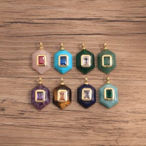 May include: Eight hexagonal pendants arranged in two rows. Each pendant features a gold-toned metal frame holding a rectangular gemstone at the center. The stones vary in color, including red, blue, clear, green, purple, and amber hues.
