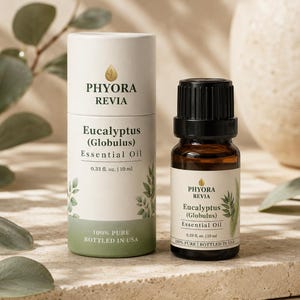 Peut inclure: Un flacon en verre ambré de 10 ml d'huile essentielle d'eucalyptus globulus Phyora Revia avec un bouchon noir, accompagné d'un tube en carton assorti. Les deux portent des étiquettes blanches avec des feuilles vertes et du texte noir.