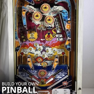 Könnte beinhalten: Ein farbenfroher Flipperkasten-Modellbausatz mit Vintage-Design. Das Kunstwerk zeigt Flugzeuge, Explosionen und die Texte "BOMBS" und "SPECIAL". Der Text "BUILD YOUR OWN PINBALL MACHINE" ist ebenfalls sichtbar. Der Bausatz ist im Maßstab 1:4.