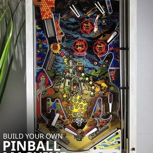 May include: A 1:4 scale DIY model kit of a pinball machine. The colorful artwork features a castle, wizard, and other fantasy elements. The text "BUILD YOUR OWN PINBALL MACHINE" is visible. The frame is white with a silver trim.