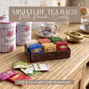 Könnte beinhalten: Ein hölzernes Miniatur-Teebeutel-Tablett mit der Aufschrift TEA TIME und bunten Teebeuteln der Marke TINYINGS. Das Set enthält verschiedene kleine Teebeutel in Blau, Gelb, Rot und Grün sowie eine Zucker- und eine Kaffeedose.