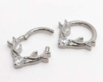 Oorbellen met transparante zirkonia in de vorm van een hertenhoorn, gemaakt van titanium, voor piercings.